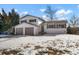 Charming two-story home with a two car garage and snow covered yard at 6190 W Canyon Ave, Littleton, CO 80128