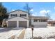 Charming two-story home with a two car garage and snow covered yard at 6190 W Canyon Ave, Littleton, CO 80128