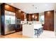 Modern kitchen with stainless steel appliances, dark wood cabinets, a center island, and bar stool seating at 4251 Perry St, Denver, CO 80212