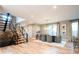 Open-concept living room with dining area, wood floors, modern staircase, and ample natural light at 4251 Perry St, Denver, CO 80212