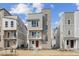 Striking three-story home featuring modern architecture, a small balcony, and a vibrant red front door at 1255 Penner Dr, Erie, CO 80026