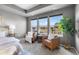 Serene bedroom with ample natural light, a tray ceiling, and comfortable seating area at 844 Dakota Ln, Erie, CO 80516
