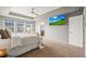 Bright main bedroom with a tray ceiling, carpet, and TV at 844 Dakota Ln, Erie, CO 80516