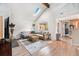 Bright living room boasts a skylight, fireplace, and sleek hardwood floors for cozy comfort at 9077 W 88Th Cir, Denver, CO 80021