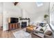 Cozy living room with a brick fireplace, modern TV console, and comfortable seating at 9077 W 88Th Cir, Denver, CO 80021