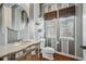 Chic powder room with designer vanity and elegant striped wallpaper and natural light at 7831 Inverness Blvd, Englewood, CO 80112