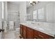 Well-maintained bathroom featuring a glass shower, a large mirror, and wood cabinets at 7831 Inverness Blvd, Englewood, CO 80112