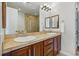 Bathroom featuring double sinks, tile countertop, and tile shower with glass door at 7831 Inverness Blvd, Englewood, CO 80112