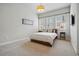 Bright bedroom featuring neutral tones, carpet, and a large window with blinds at 7831 Inverness Blvd, Englewood, CO 80112