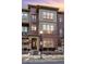 Beautiful three-story townhouse with a brick facade, lovely windows, and an inviting entrance at 7831 Inverness Blvd, Englewood, CO 80112