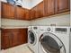 Well-organized laundry room with dark cabinetry, tile floor, and modern LG washer and dryer at 7831 Inverness Blvd, Englewood, CO 80112