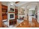 Bright living room with hardwood floors, built-in shelves, a fireplace, and exposed beams at 7831 Inverness Blvd, Englewood, CO 80112