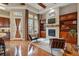 Cozy living room with built-in shelves, fireplace, hardwood floors, and ample natural light at 7831 Inverness Blvd, Englewood, CO 80112