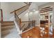 Inviting staircase with carpeted steps, wood railing, and hardwood flooring at 7831 Inverness Blvd, Englewood, CO 80112