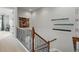 Staircase landing with wood and metal railing, light carpet, and neutral wall color at 7831 Inverness Blvd, Englewood, CO 80112