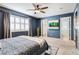 Spacious bedroom with ceiling fan, shuttered windows, patterned bedding, and ensuite bathroom access at 10978 Ashurst Ln, Highlands Ranch, CO 80130