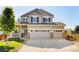 Charming two-story home featuring a three car garage, well-manicured lawn, and inviting front porch at 10978 Ashurst Ln, Highlands Ranch, CO 80130