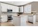 Well-lit kitchen featuring white cabinets, stainless steel appliances, and a functional center island at 10978 Ashurst Ln, Highlands Ranch, CO 80130