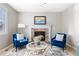 Cozy living room featuring a brick fireplace, two blue chairs, and a decorative rug at 10978 Ashurst Ln, Highlands Ranch, CO 80130