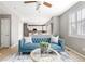 Open-concept living room with blue couch and views of the kitchen and its modern appliances at 10978 Ashurst Ln, Highlands Ranch, CO 80130