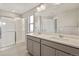Modern bathroom with double vanity, a large mirror and glass enclosed shower at 14249 Beebalm Ave, Parker, CO 80134
