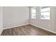 Bright bedroom with light grey walls, wood-look flooring, and large window at 14249 Beebalm Ave, Parker, CO 80134