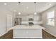 Bright kitchen features stainless steel appliances, grey cabinets, and a large center island with sink at 14249 Beebalm Ave, Parker, CO 80134