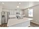 Bright kitchen features stainless steel appliances, grey cabinets, and a large center island with sink at 14249 Beebalm Ave, Parker, CO 80134