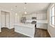 Bright kitchen features stainless steel appliances, grey cabinets, and a large center island with sink at 14249 Beebalm Ave, Parker, CO 80134