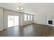 Spacious living room with wood floors, sliding glass doors, and a contemporary chandelier at 14249 Beebalm Ave, Parker, CO 80134