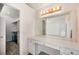 Bright bathroom featuring a white vanity and a large mirror, with a walk-in closet adjacent at 17045 Hastings Ave, Parker, CO 80134