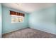 Bedroom featuring plush carpeting, neutral colored walls and a large window at 17045 Hastings Ave, Parker, CO 80134