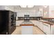 Updated kitchen features an island, stainless steel appliances, and ample counter space with light tile flooring at 17045 Hastings Ave, Parker, CO 80134