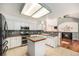 A well-lit kitchen with white cabinets, stainless steel appliances, and direct view into a cozy living room at 17045 Hastings Ave, Parker, CO 80134