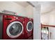 Convenient laundry area with a vibrant red washer and dryer set, located near the second floor landing at 17045 Hastings Ave, Parker, CO 80134