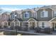 Attractive townhome showcasing a private front patio, lush landscaping, and detailed architectural features at 16047 E Geddes Ln # 128, Aurora, CO 80016