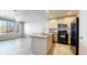 Kitchen with light wood cabinets, a peninsula with a sink, and black appliances at 16047 E Geddes Ln # 128, Aurora, CO 80016