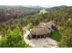 Aerial view showcasing a luxurious home with a three-car garage, surrounded by lush forest and mountain views at 2548 Keystone Dr, Evergreen, CO 80439