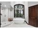 Elegant bathroom with a standalone tub, walk-in shower, and a large window overlooking the trees at 2548 Keystone Dr, Evergreen, CO 80439