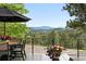 Relax and entertain on this deck with mountain views, an outdoor dining set, and lush landscaping at 2548 Keystone Dr, Evergreen, CO 80439