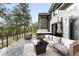 Outdoor living space with a hot tub and comfortable seating area, surrounded by lush trees and greenery at 2548 Keystone Dr, Evergreen, CO 80439