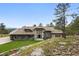 Front exterior view of a luxury home featuring stone accents, manicured landscaping, and a grand entrance at 2548 Keystone Dr, Evergreen, CO 80439