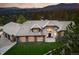 Beautiful stone and stucco home with a tile roof, large windows, and well-manicured lawn at 2548 Keystone Dr, Evergreen, CO 80439