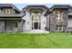 Luxury home featuring a stone facade, manicured lawn, and porte-cochere with a tile roof at 2548 Keystone Dr, Evergreen, CO 80439