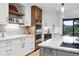 Well-lit kitchen boasts stainless appliances, white countertops, and a wood accent wall at 2548 Keystone Dr, Evergreen, CO 80439