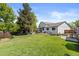 Large, green backyard featuring a well-maintained lawn, patio seating, a stock tank pool, and mature trees at 7633 S Gilpin Ct, Centennial, CO 80122