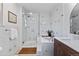 Bright bathroom featuring white marble tile, a walk-in shower, and double sinks at 7633 S Gilpin Ct, Centennial, CO 80122