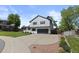 Charming two-story home with a well-manicured lawn, mature trees, and a long driveway leading to a garage at 7633 S Gilpin Ct, Centennial, CO 80122