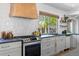 Well-appointed kitchen showcasing range, custom hood, and bright natural light from a large window at 7633 S Gilpin Ct, Centennial, CO 80122