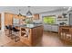 Spacious kitchen with a large island, modern lighting, stainless appliances, and hardwood floors at 7633 S Gilpin Ct, Centennial, CO 80122